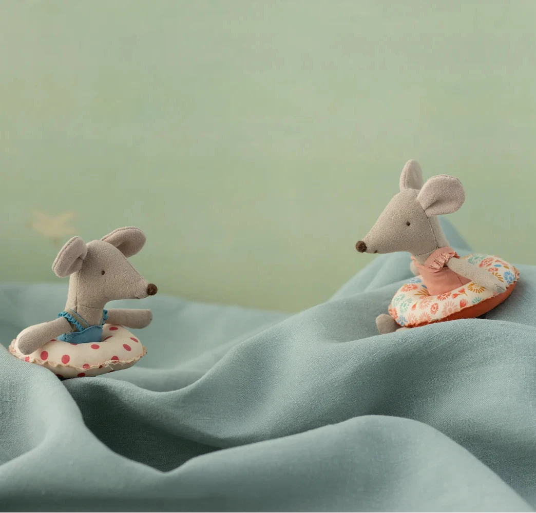 Stuffed toy of a mouse in a pink swimsuit with a flower-printed float around its stomach.