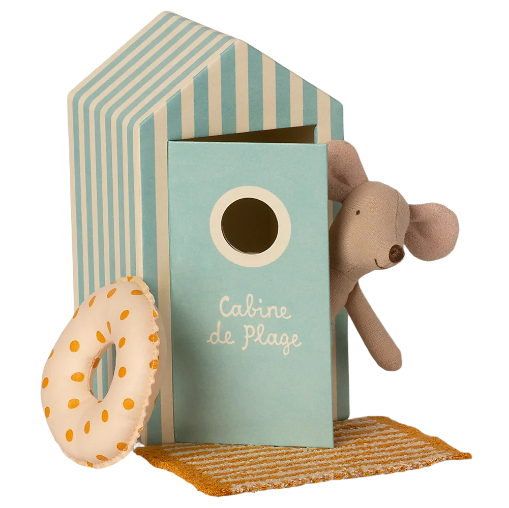 Toy beach hut with a teddy bear, donut, and towel on a white background