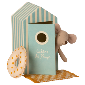 Toy beach hut with a teddy bear, donut, and towel on a white background