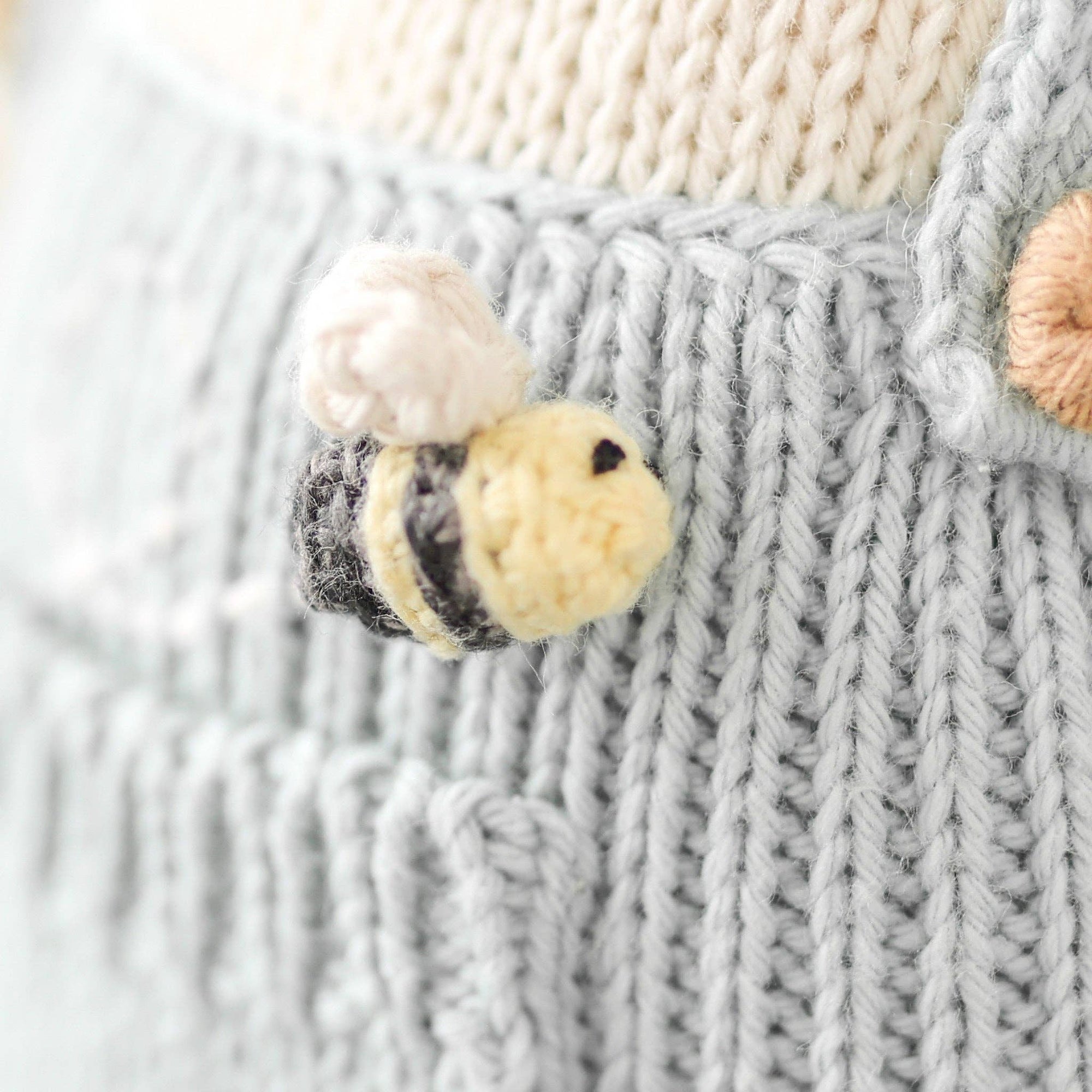 An up close detail of the bee on the honey bear stuffed animal. 