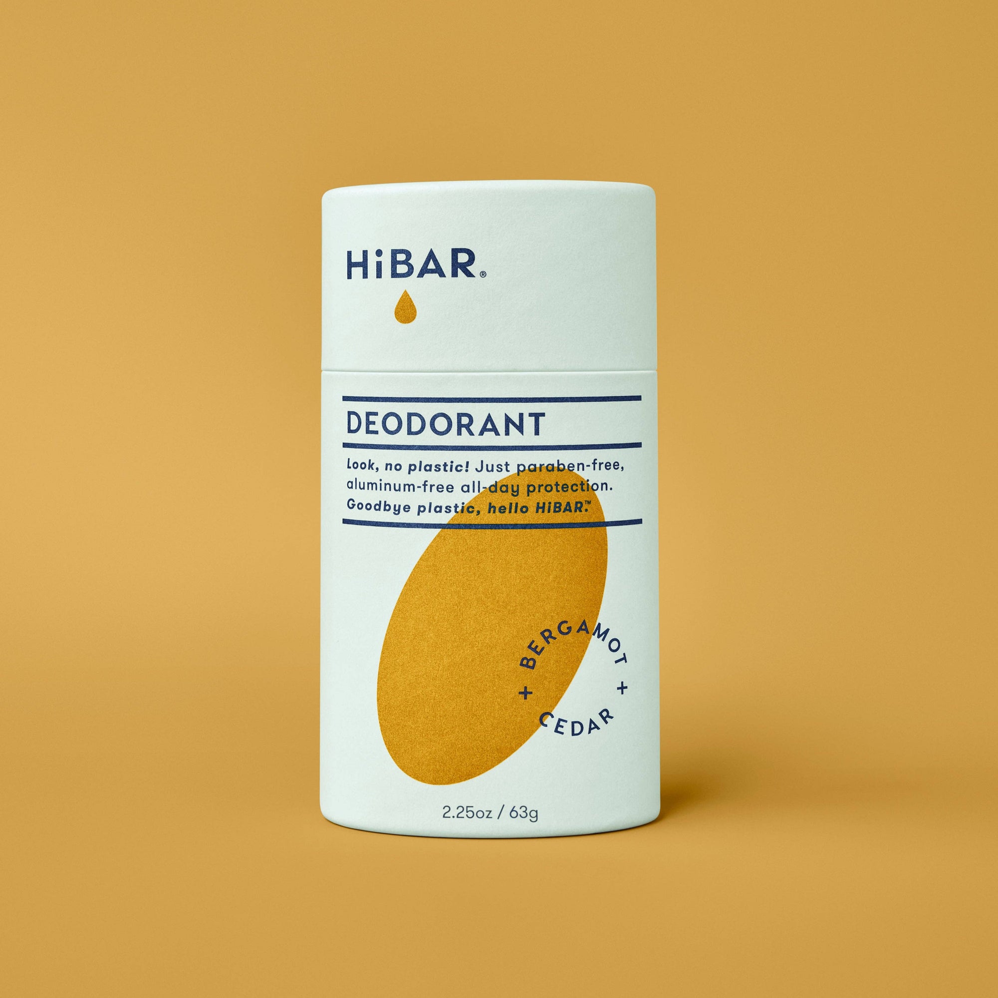 A tube of  hibar bergamot cedar deodorant on an orange background. 