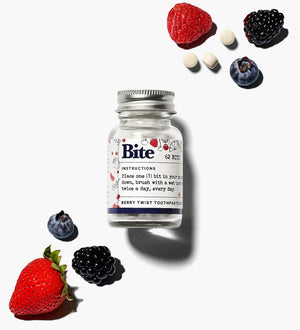 A bottle of bite berry toothpaste tablets, with fruit and berries. 