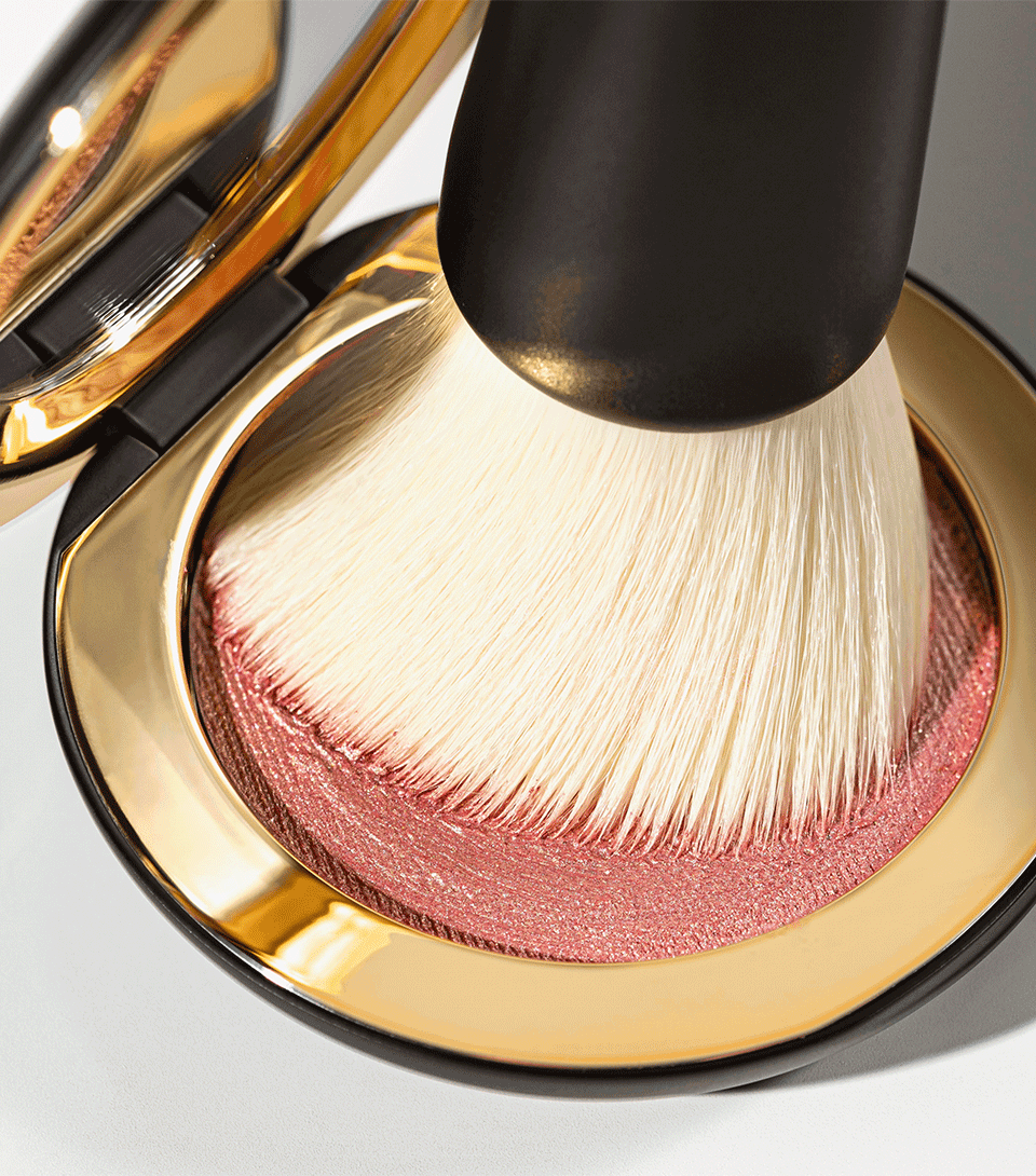 A black and white blender brush with a flat synthetic head and a black wooden handle.