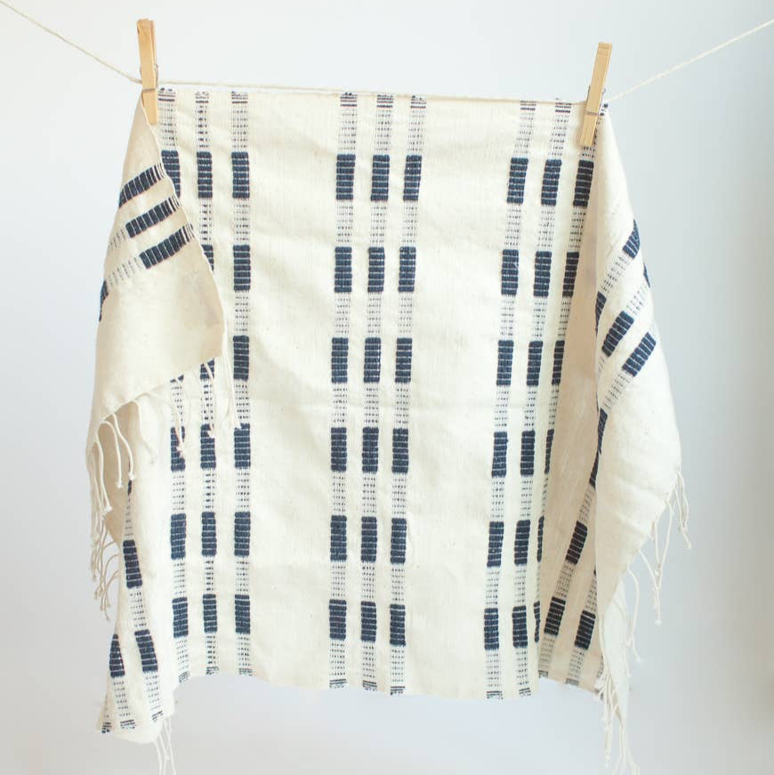 An ochre and white tea towel with a clothespin.