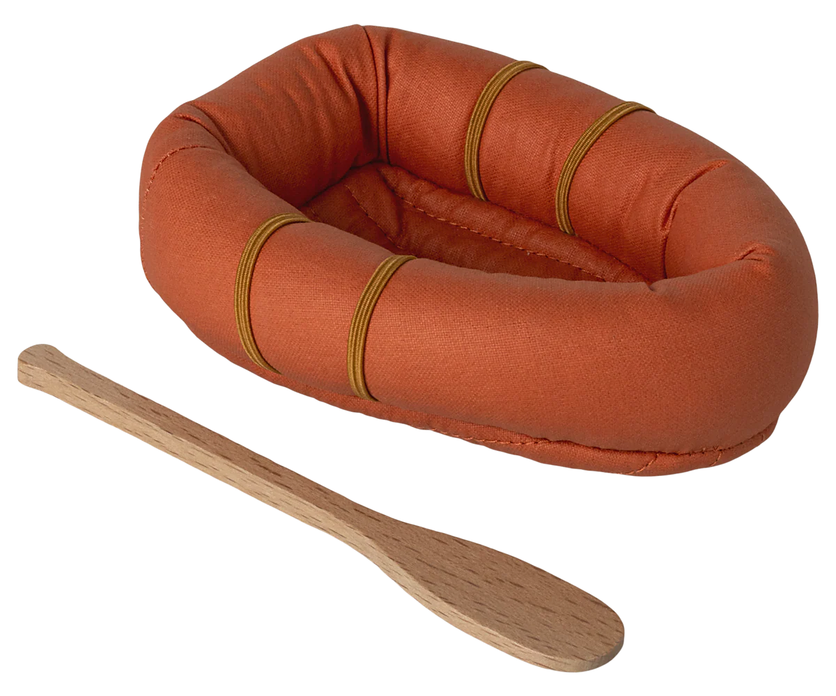 An orange dollhouse sized raft with paddle