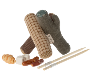 An assortment of toy camping items including a fabric bonfire, sticks, marshmallows, bread, and sausages designed for play with small mouse figures.