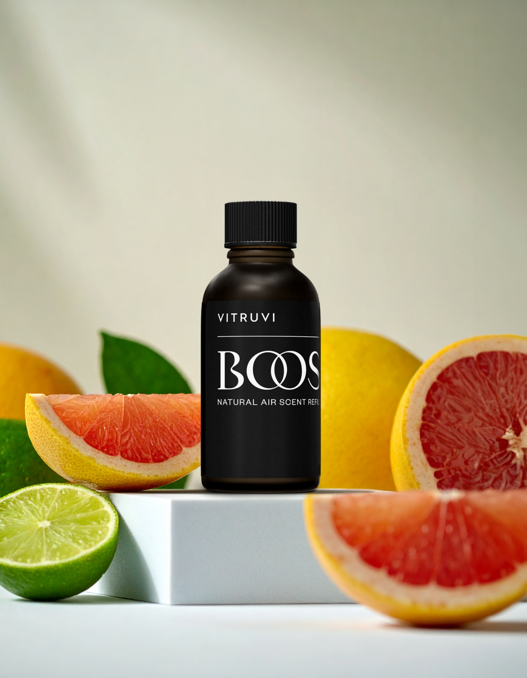 Vitruvi Boost natural air scent bottle with citrus fruits on a neutral background