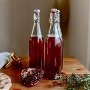 Three glass swing top bottles with red liquid