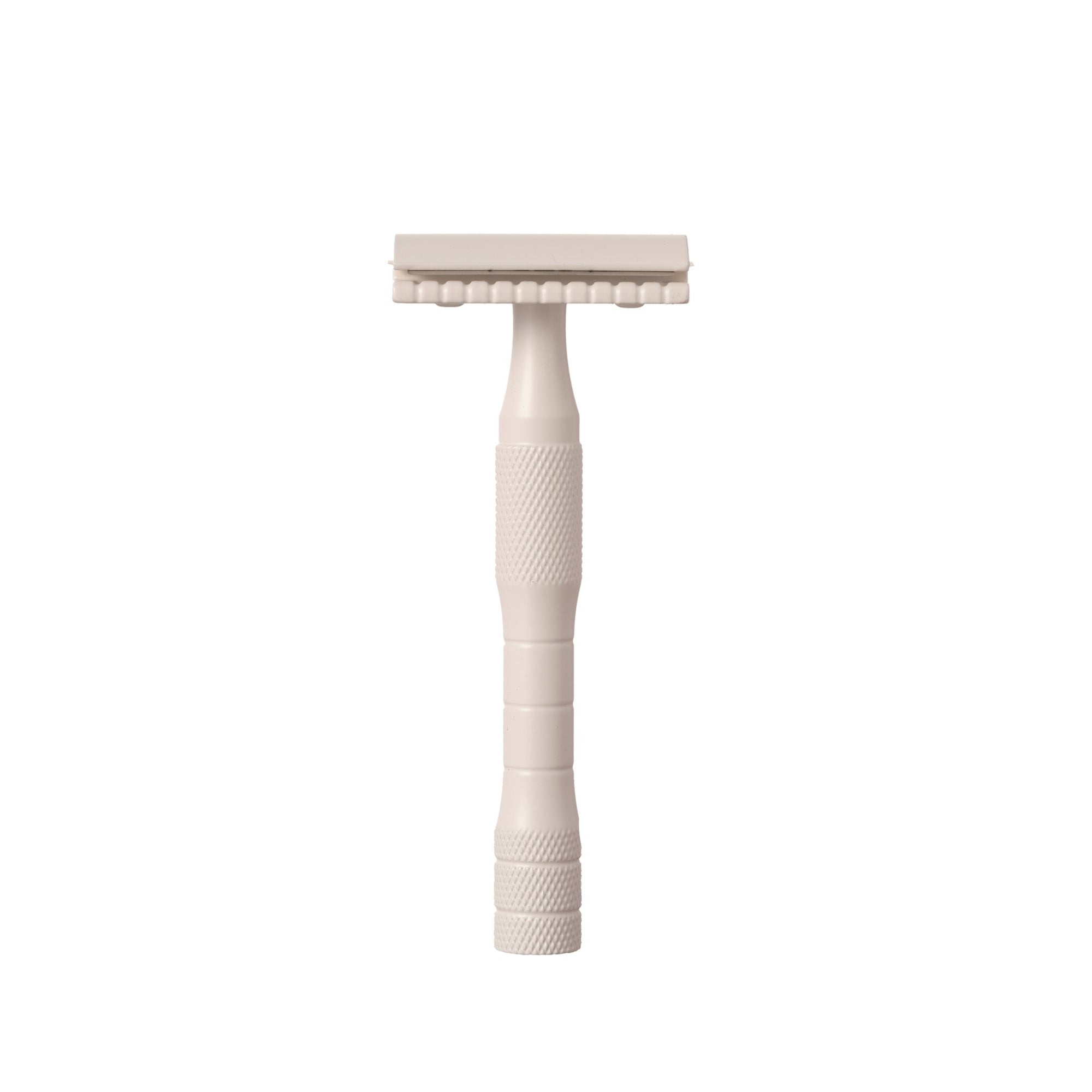 A brass safety razor with a stainless steel blade, cream-colored handle, and textured grip area.