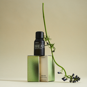 Black bottle labeled 'BREATHE' with green packaging and a branch on a beige background