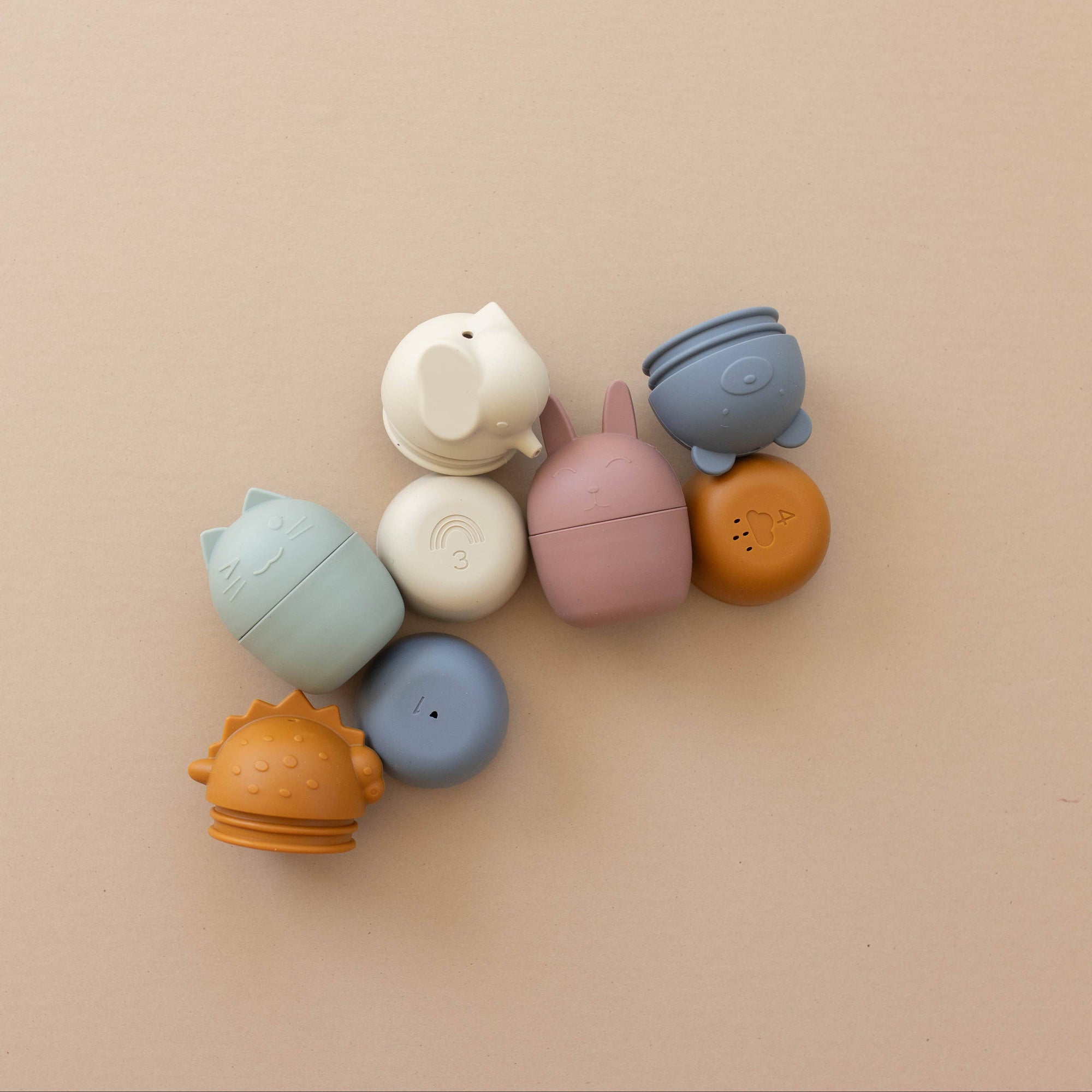 Colorful silicone teether toys on a beige background