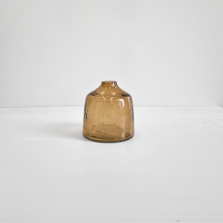 A handblown hammered glass bud vase in brown.