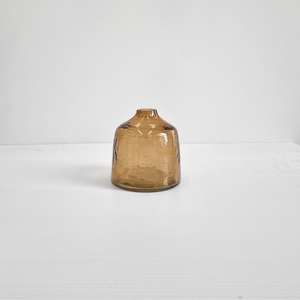 A handblown hammered glass bud vase in brown.