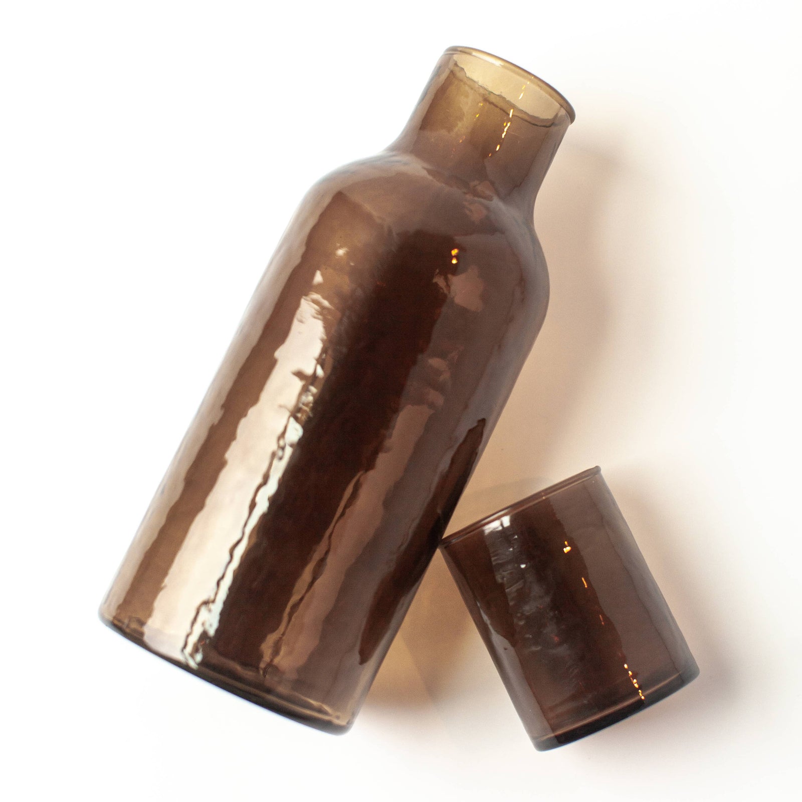 A brown glass decanter with a brown glass lid that serves as a cup. 