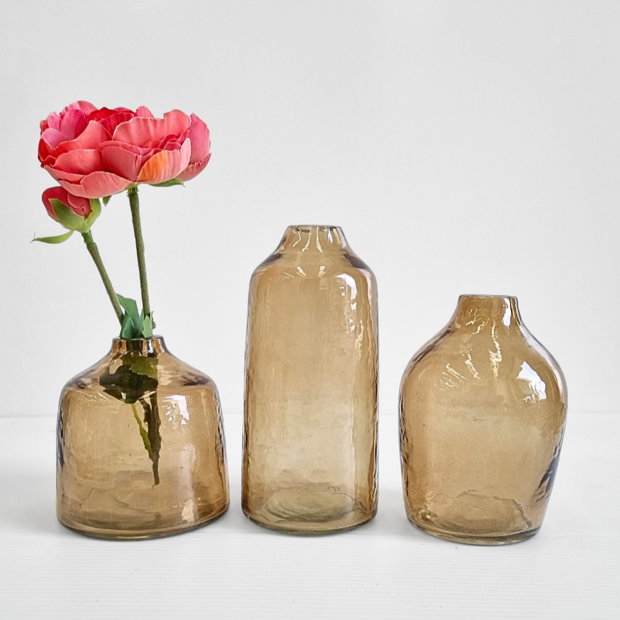 Three brown glass bud vases with an ink flower. 