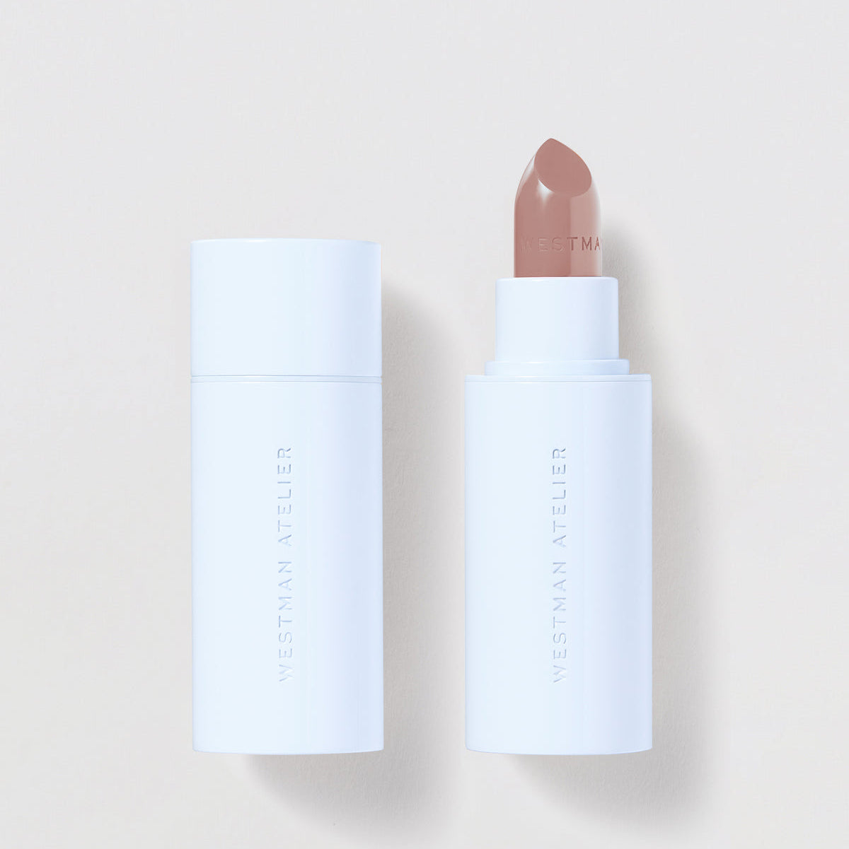 Lipstick with white casing on a light beige background