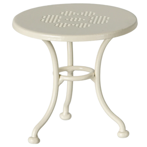 White metal table with a perforated design on a white background