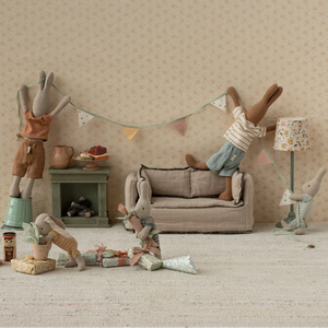 Miniature scene with toy figures in a living room setting.