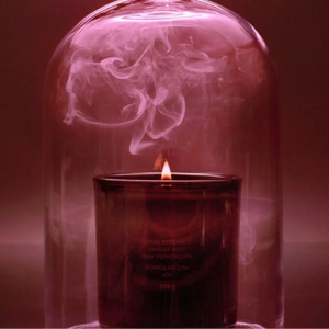 The Flamingo Estate night blooming jasmine and damask rose candle, in a green glass vessel covered with a glass cloche