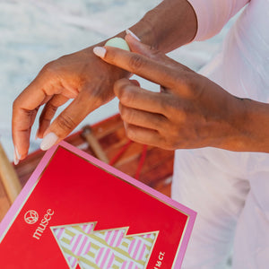 Close-up of hands holding a red card with a geometric design, blurred background