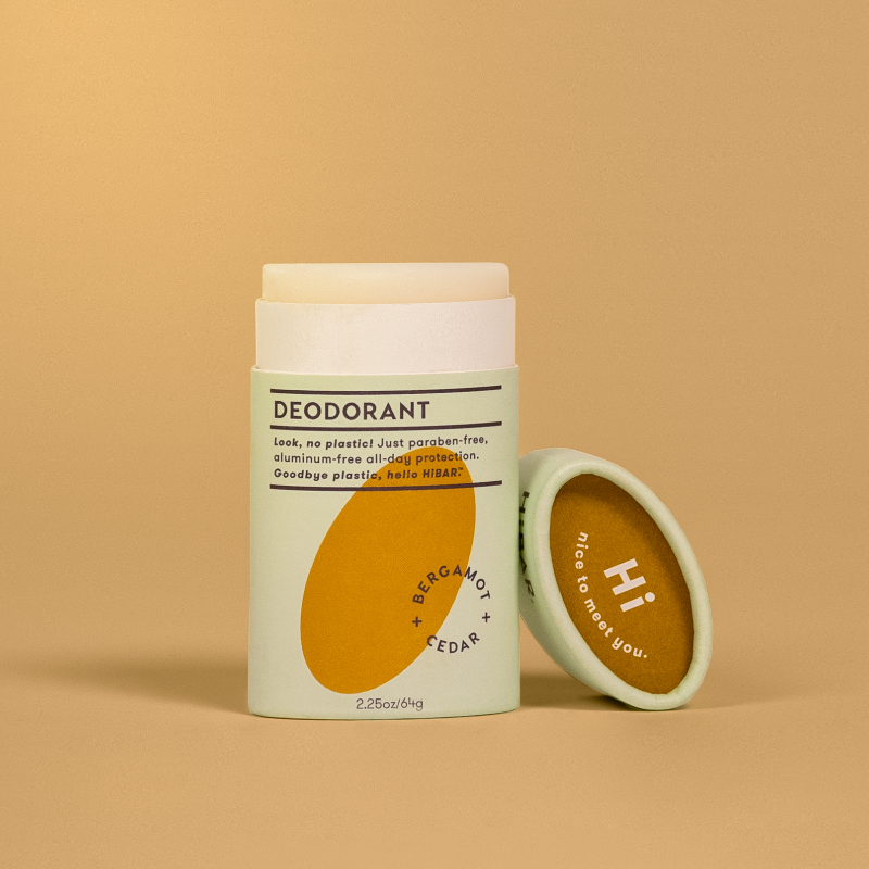 A tube of hibar bergamot cedar deodorant on an orange background. 