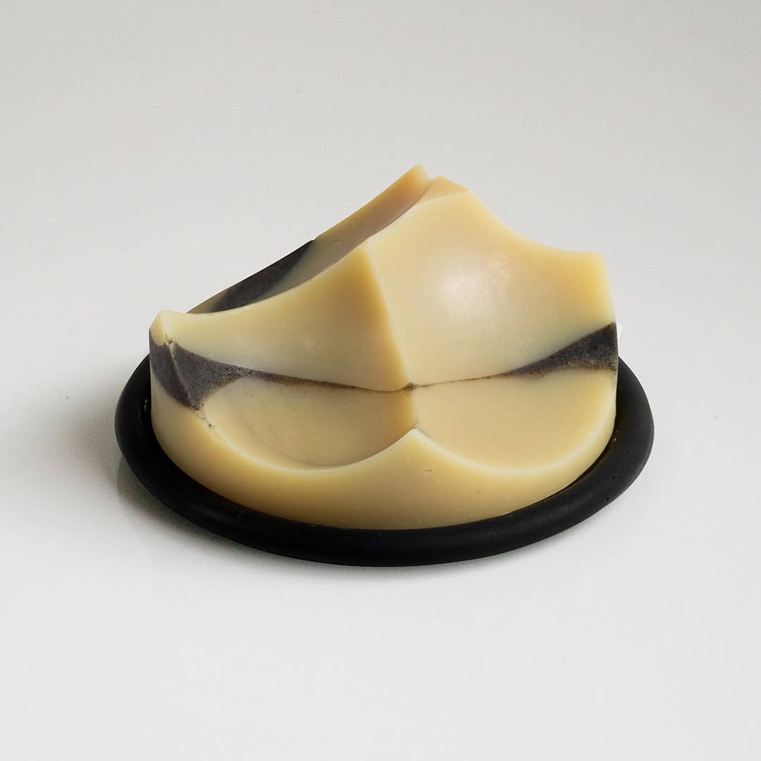 An UME Studios cedar sandalwood soap, on a black buton