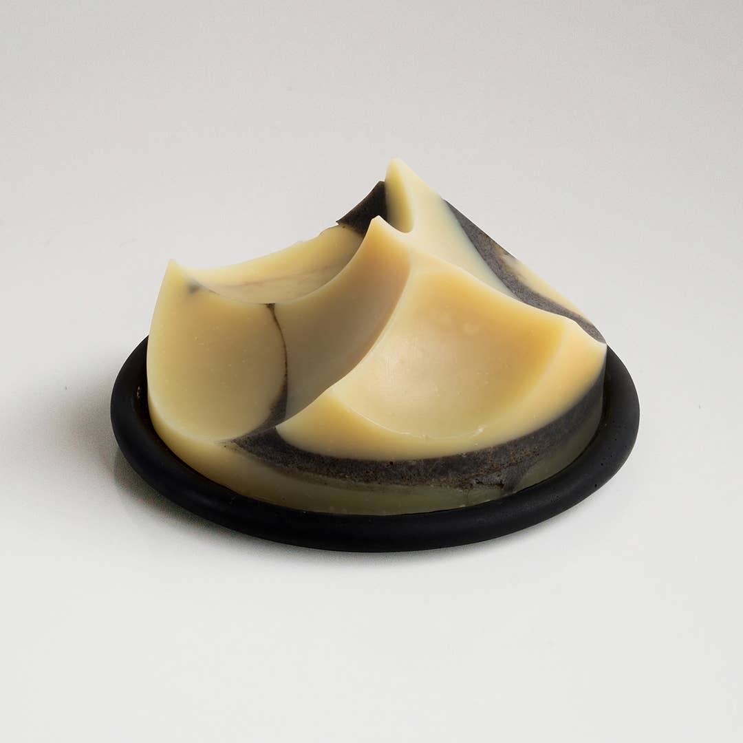 An UME Studios cedar sandalwood soap, on a black buton