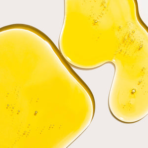 Close-up of yellow liquid with bubbles on a white background