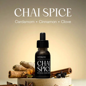 Vitruvi Chai Spice essential oil bottle with cardamom, cinnamon, and clove on a beige background