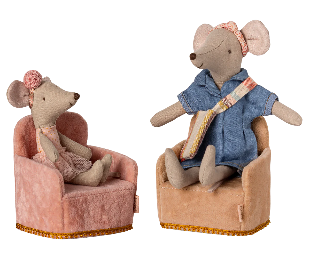 Two toy mice sitting on chairs with a white background