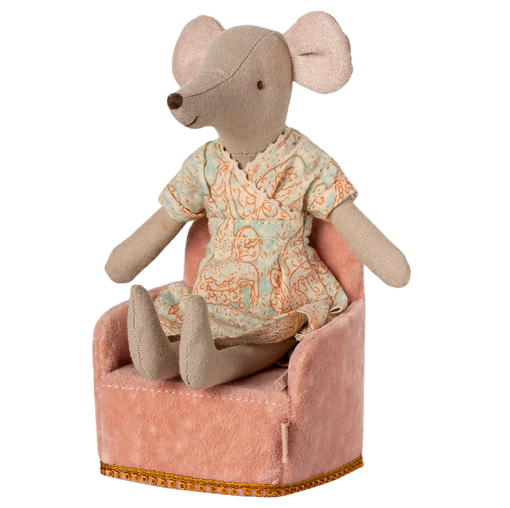 Stuffed mouse toy in pajamas sitting on a small pink chair with a white background