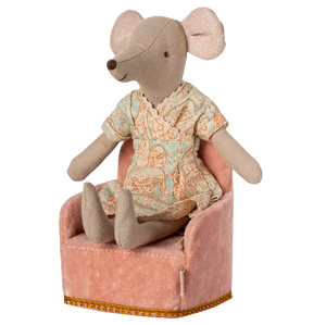 Stuffed mouse toy in pajamas sitting on a small pink chair with a white background