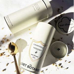Two white containers with 'The Quiet Botanist' branding on a light background with decorative elements.
