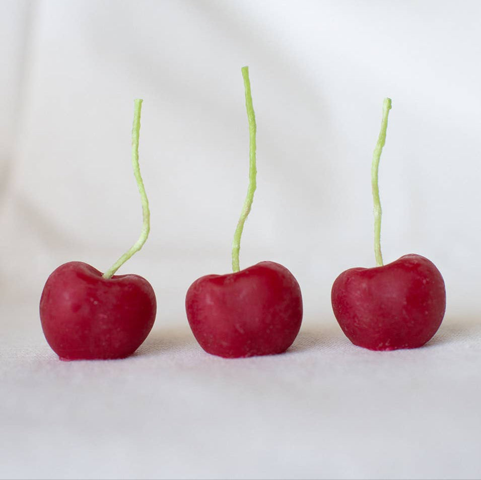 A group of three organic beeswax cherry candles, made by hand in California by Happy Organics