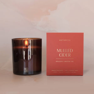 Candle and its packaging labeled 'Mulled Cider' on a soft pink background
