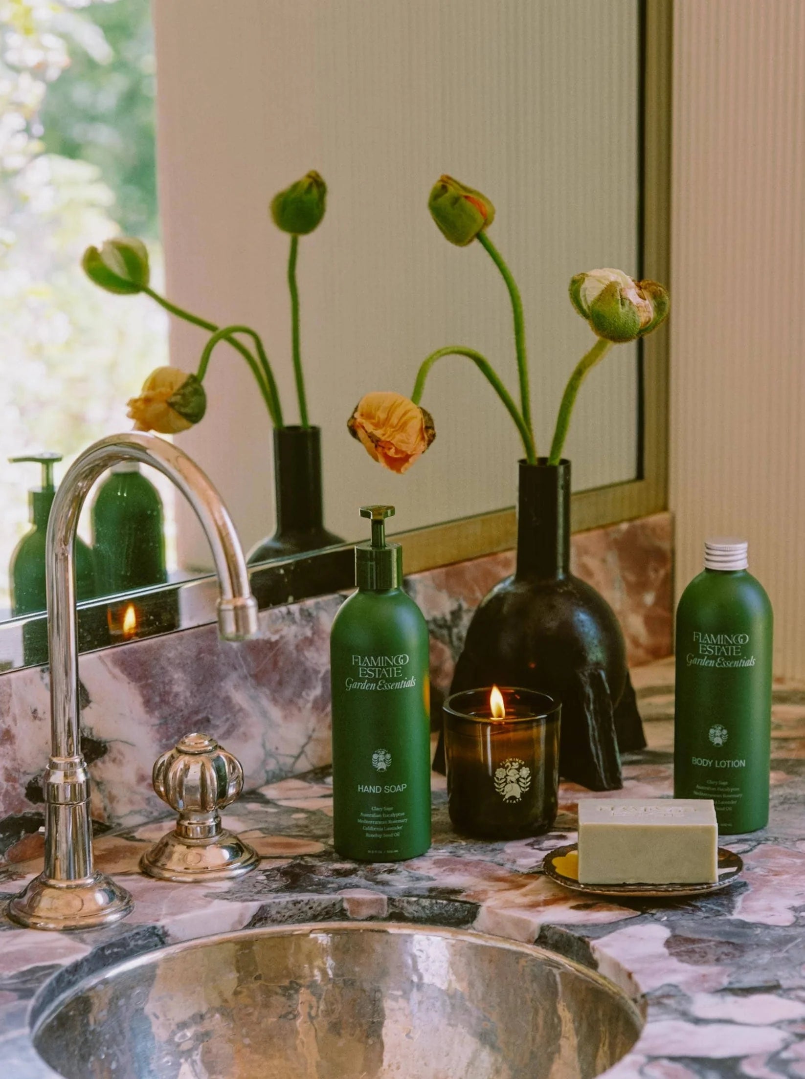 Flamingo Estate Garden Essentials Clary Sage hand soap, on a bathroom counter with poppies.