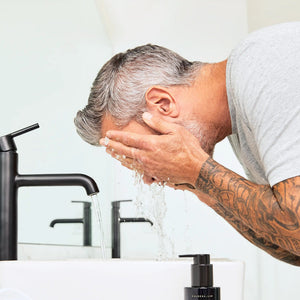 A man washing his face. 