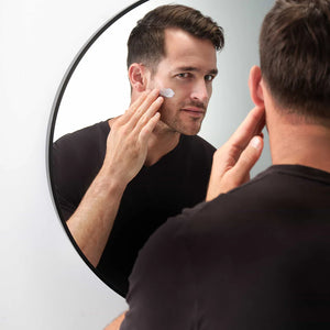 A man applying moisturizer to his face. 