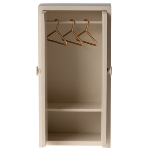 Beige wall-mounted cabinet with gold hangers on a white background