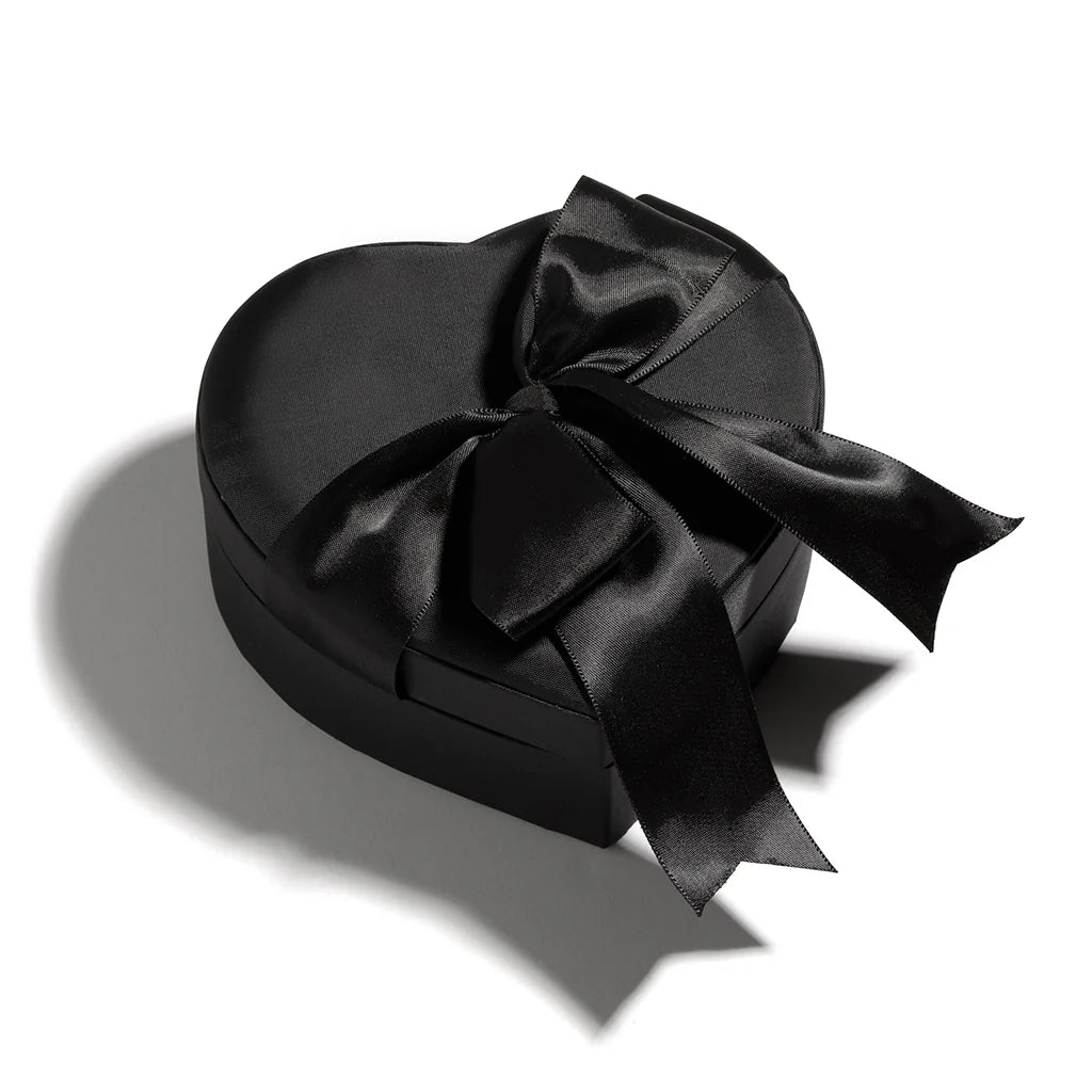 A bottle of Heretic Coeur Noir next to a black satin heart-shaped box