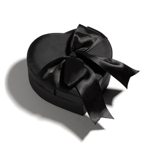 A bottle of Heretic Coeur Noir next to a black satin heart-shaped box