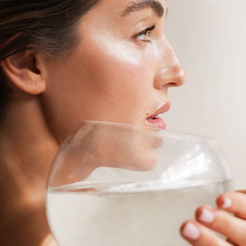 A woman holding a glass to her face