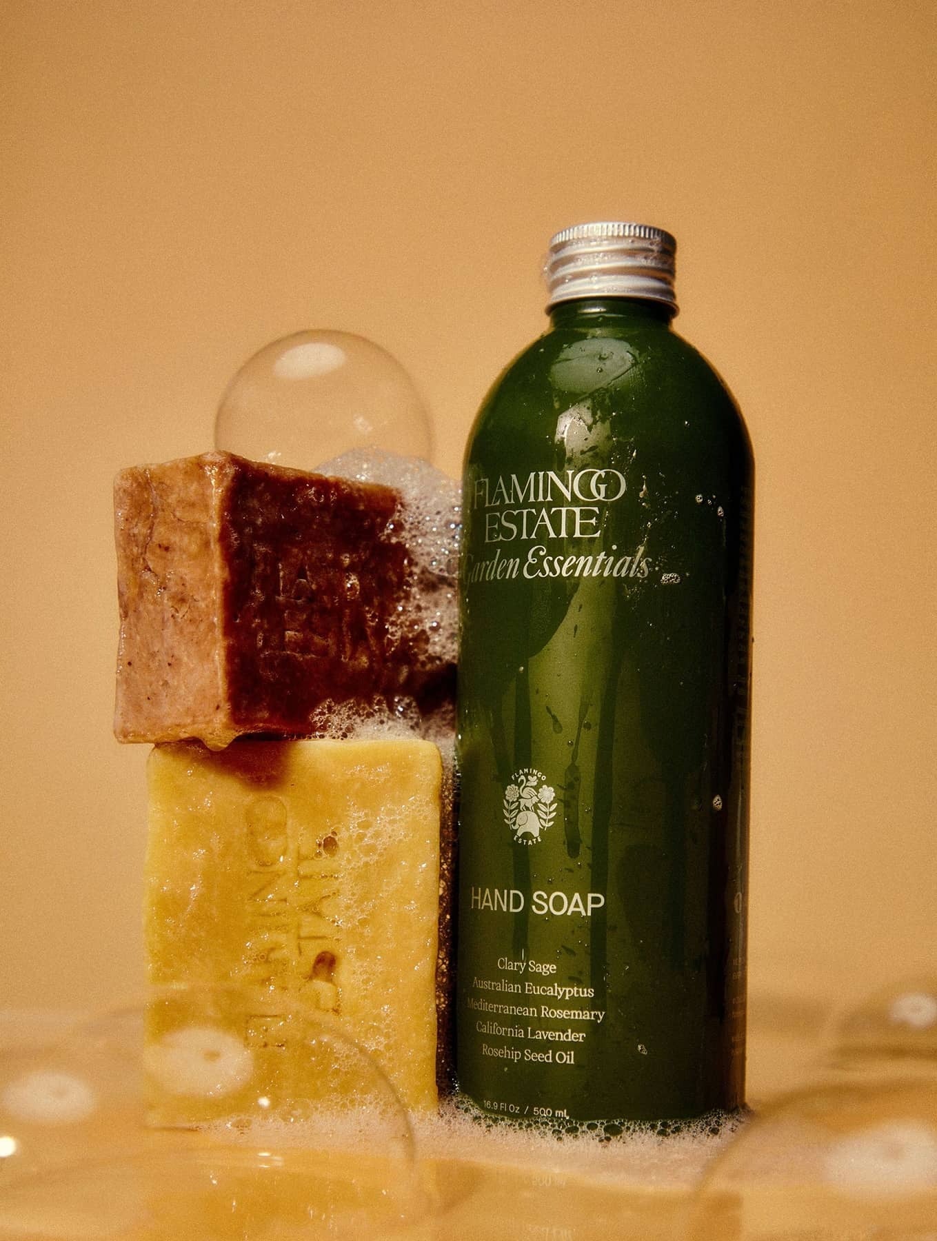 Flamingo Estate Garden Essentials Clary Sage hand soap, next to two soap bricks