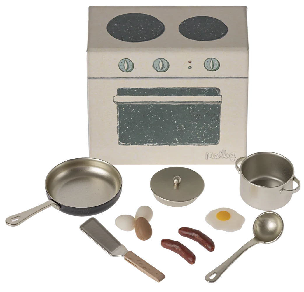 Miniature kitchen set with stove and utensils on a white background
