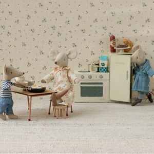 Miniature mouse family scene with a refrigerator, stove, and table.