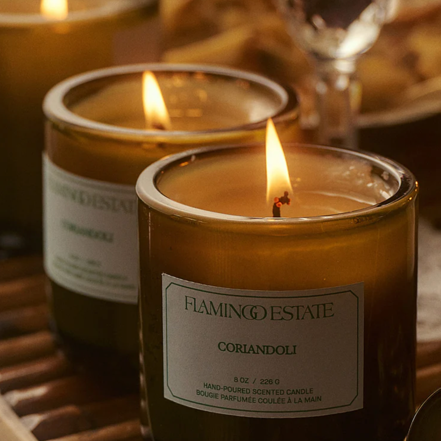 The Flamingo Estate Coriandoli candle, in a green glass vessel