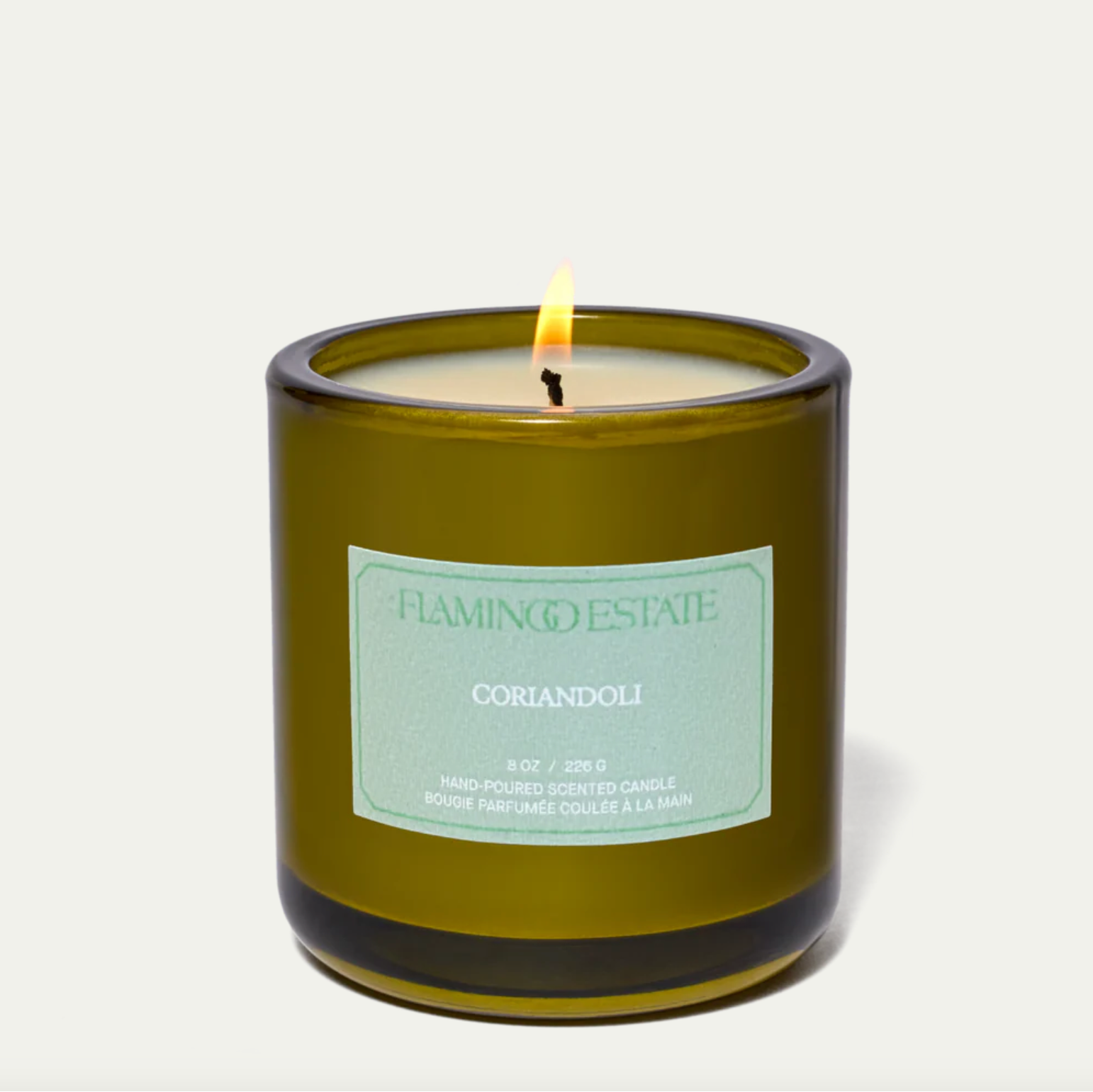 The Flamingo Estate Coriandoli candle, in a green glass vessel