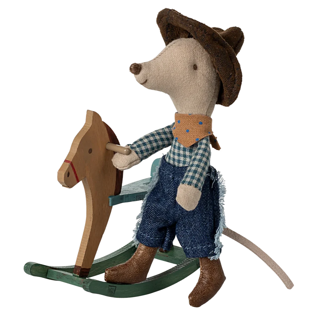 A plush toy mouse dressed as a cowboy, with a blue bandana, brown hat, and blue jeans, riding a small wooden rocking horse.