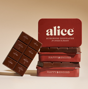 Red chocolate tin labeled 'alice' with a chocolate bar on a beige background