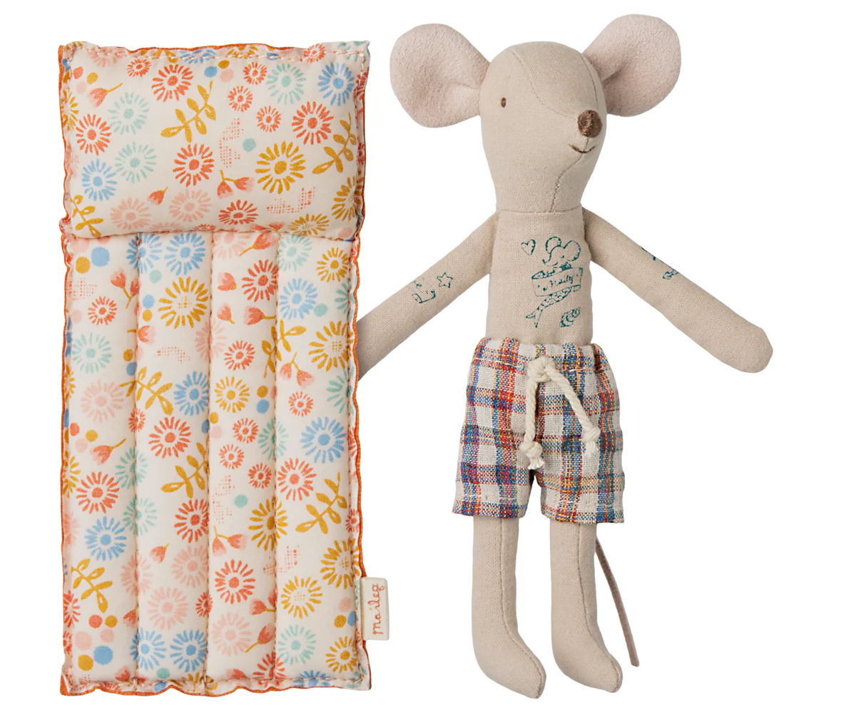 A toy mouse in beige color with a floral patterned air mattress.